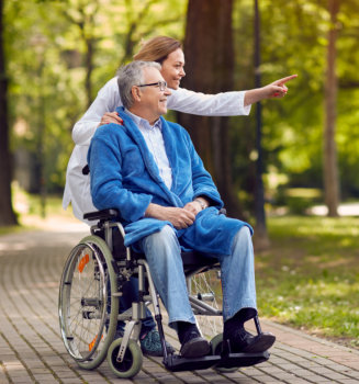 woman pointing at a location with an elderly man in wheelchair